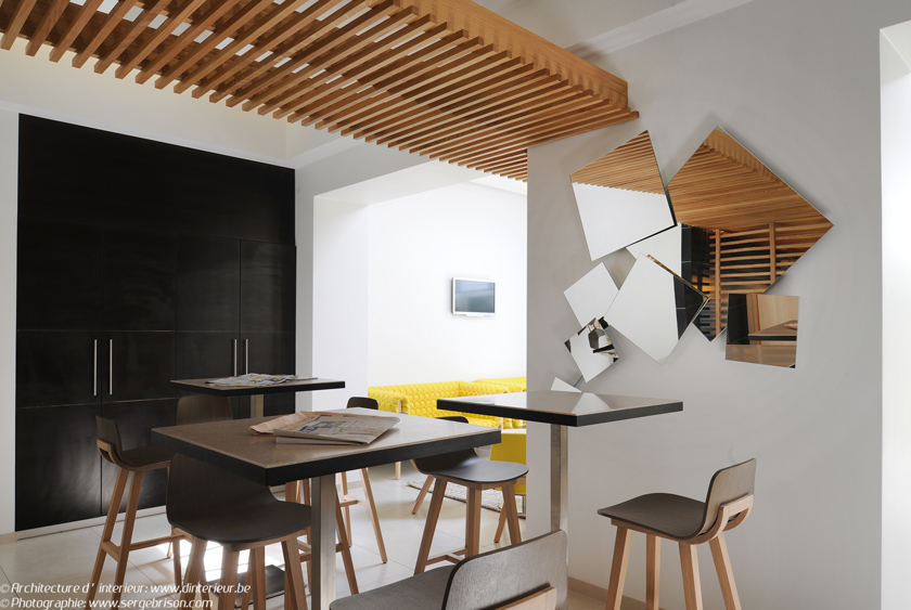 dinterieur diseño de interiores de hotel zona comunitaria espejo geométrico taburetes de madera barra alta