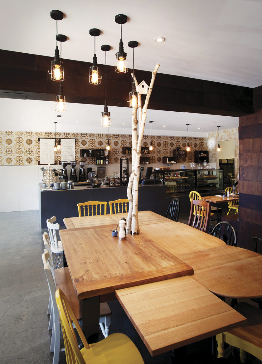 luces industriales suspendidas mesa con ramas de árbol baldosas retro en la pared mesa reciclada