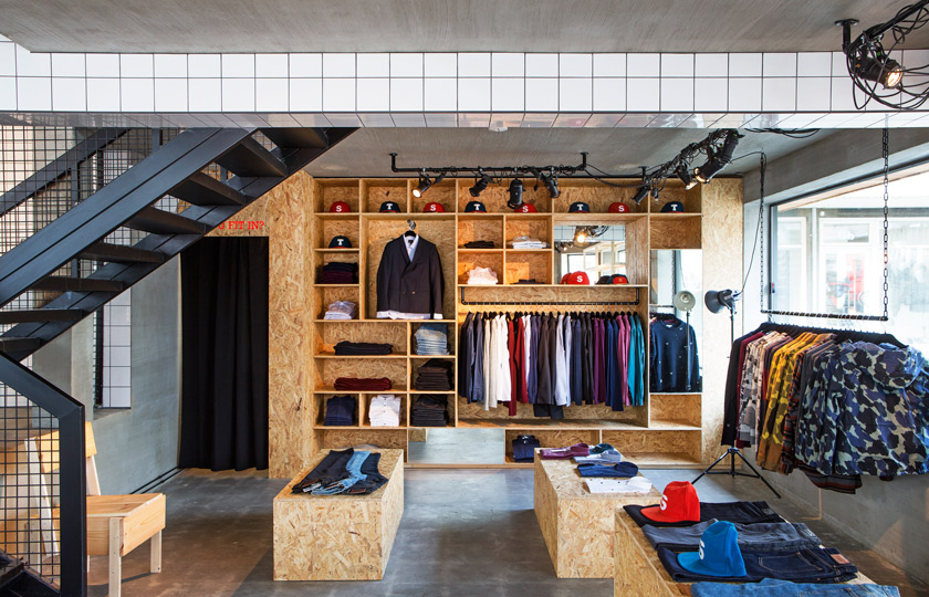 Suit Store de HAFstudio tienda de ropa de diseño estilo industrial con revestimientos de hormigón y tablero OSB
