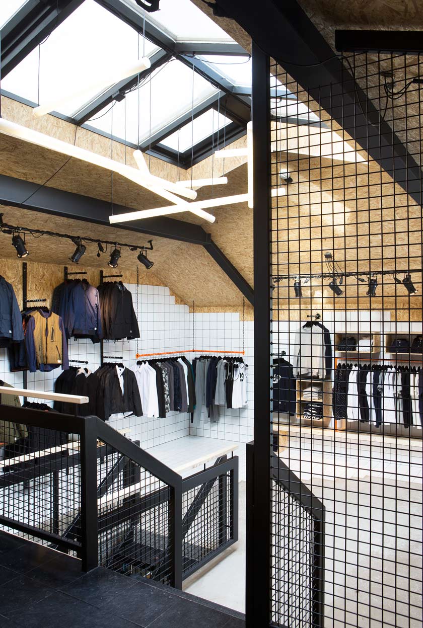 diseño comercial interior tienda de ropa moda fluorescentes cruzados iluminación interior escaleras 