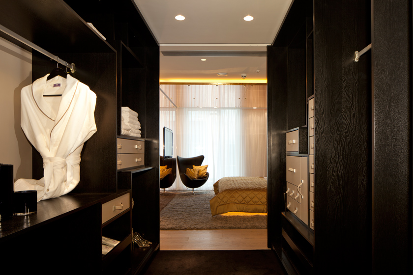 armario grande de madera negra albornoz blanco pasillo comunicar alfombra marrón
