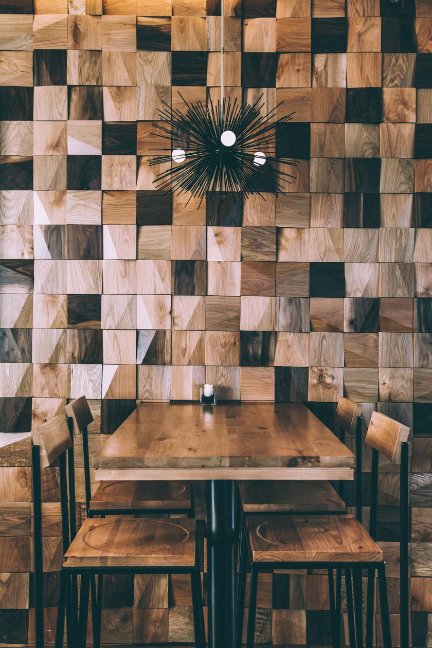 mesa con sillas y taburetes de madera diferentes tonos luz de erizo restaurante japonés diseño