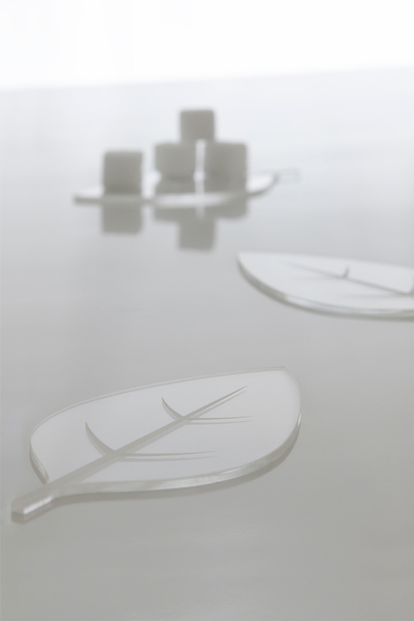 azucarero en forma de hoja de cristal transparente silueta simplificada sobre mesa blanca