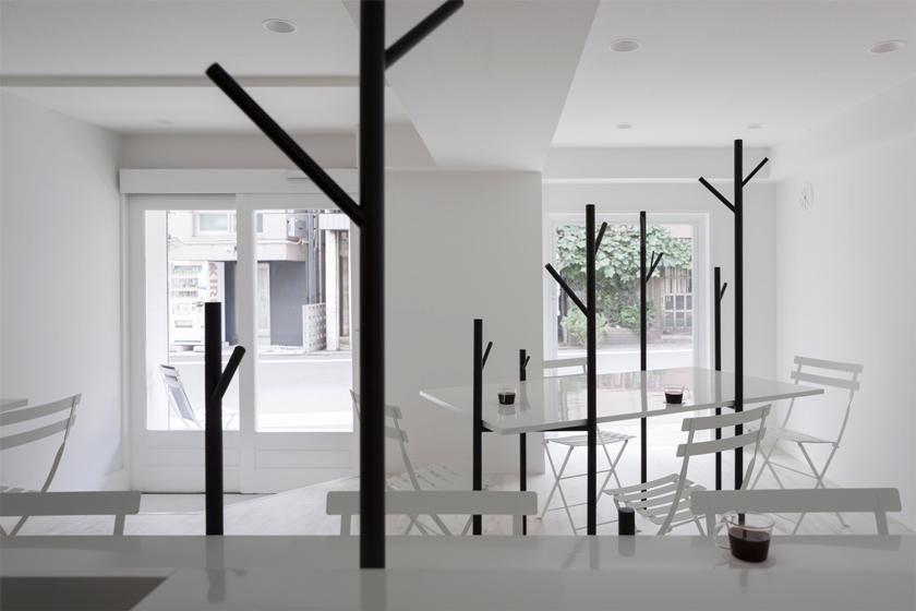 cafe ki con sillas mesas y revestimiento en blanco ventanal entrada principal con carpintería en blanco