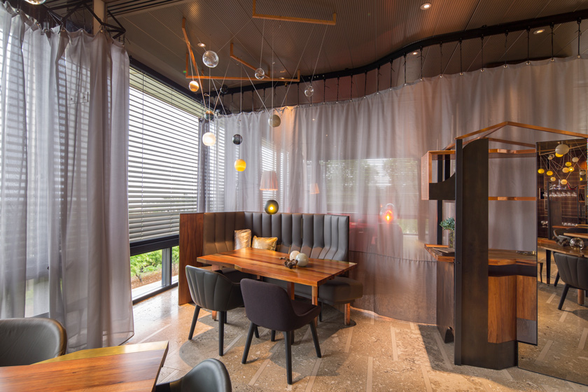 Pascale Gomes-McNabb restaurante zona comedor sillas y bancos grises mesas de madera australiana cortinas de separador